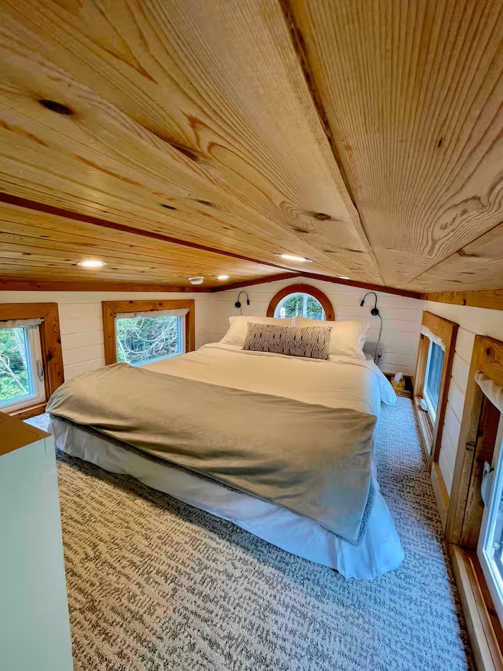 Cozy loft bedroom with queen bed and round window