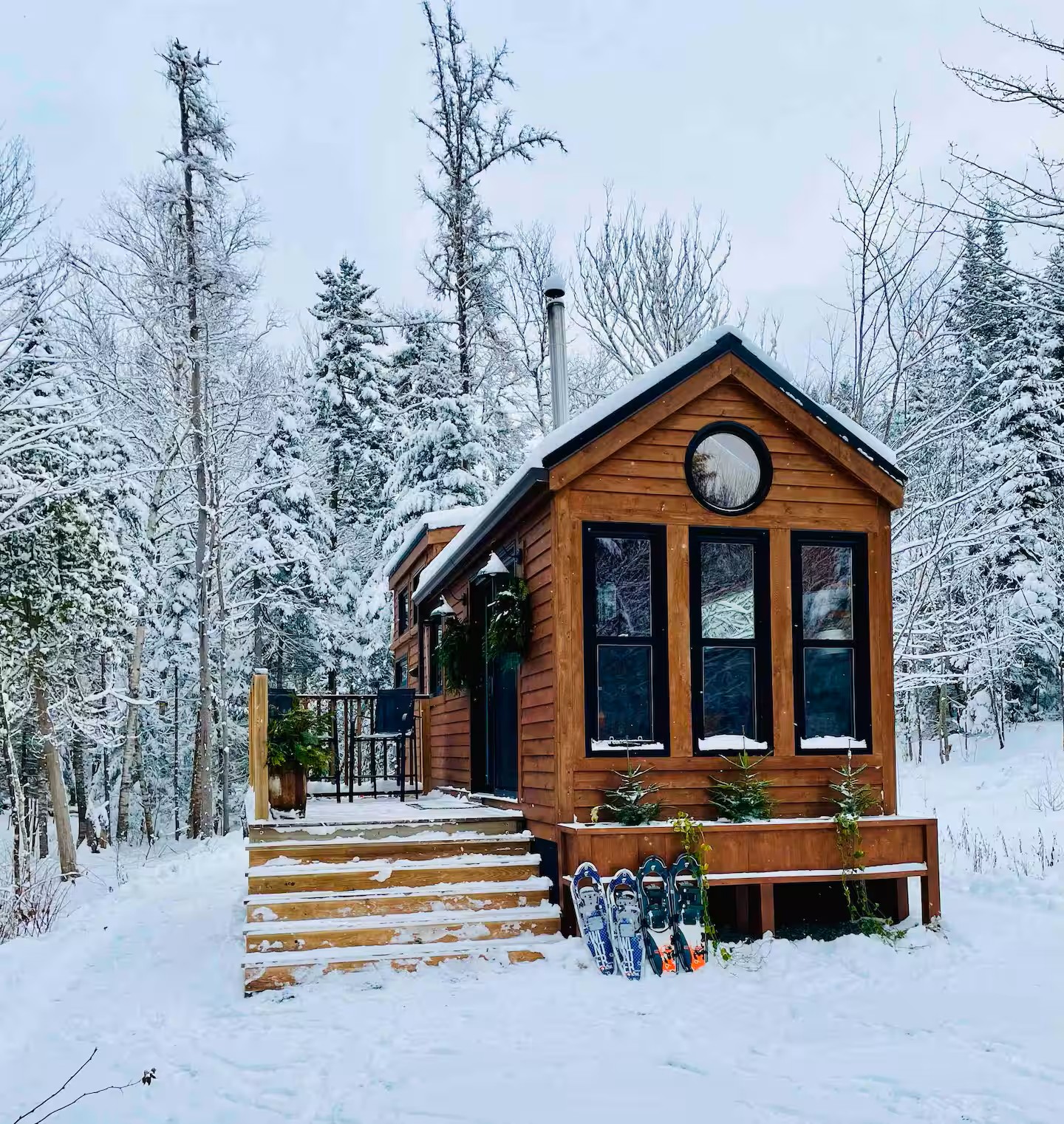 Tiny house in winter with snowshoes on the steps