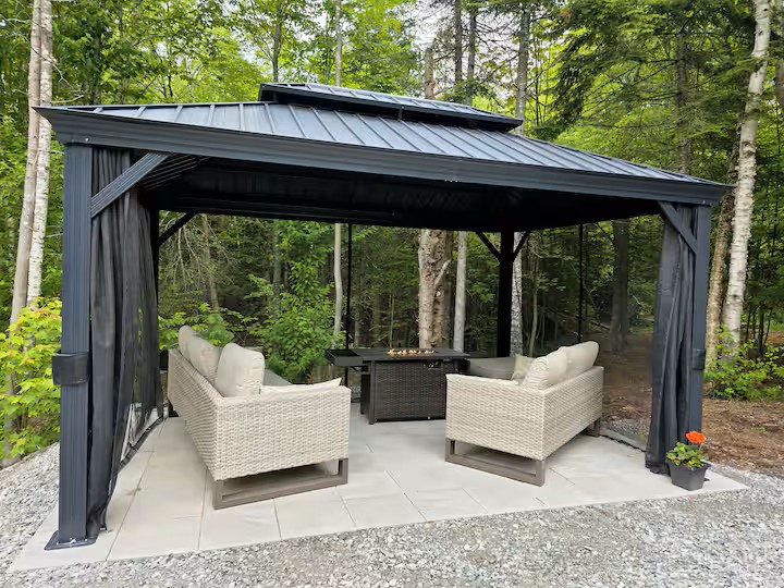 Screened gazebo with wicker furniture and fire table