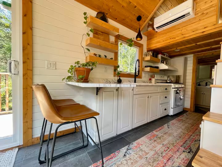 Well-equipped kitchen with marble counter and wood shelves
